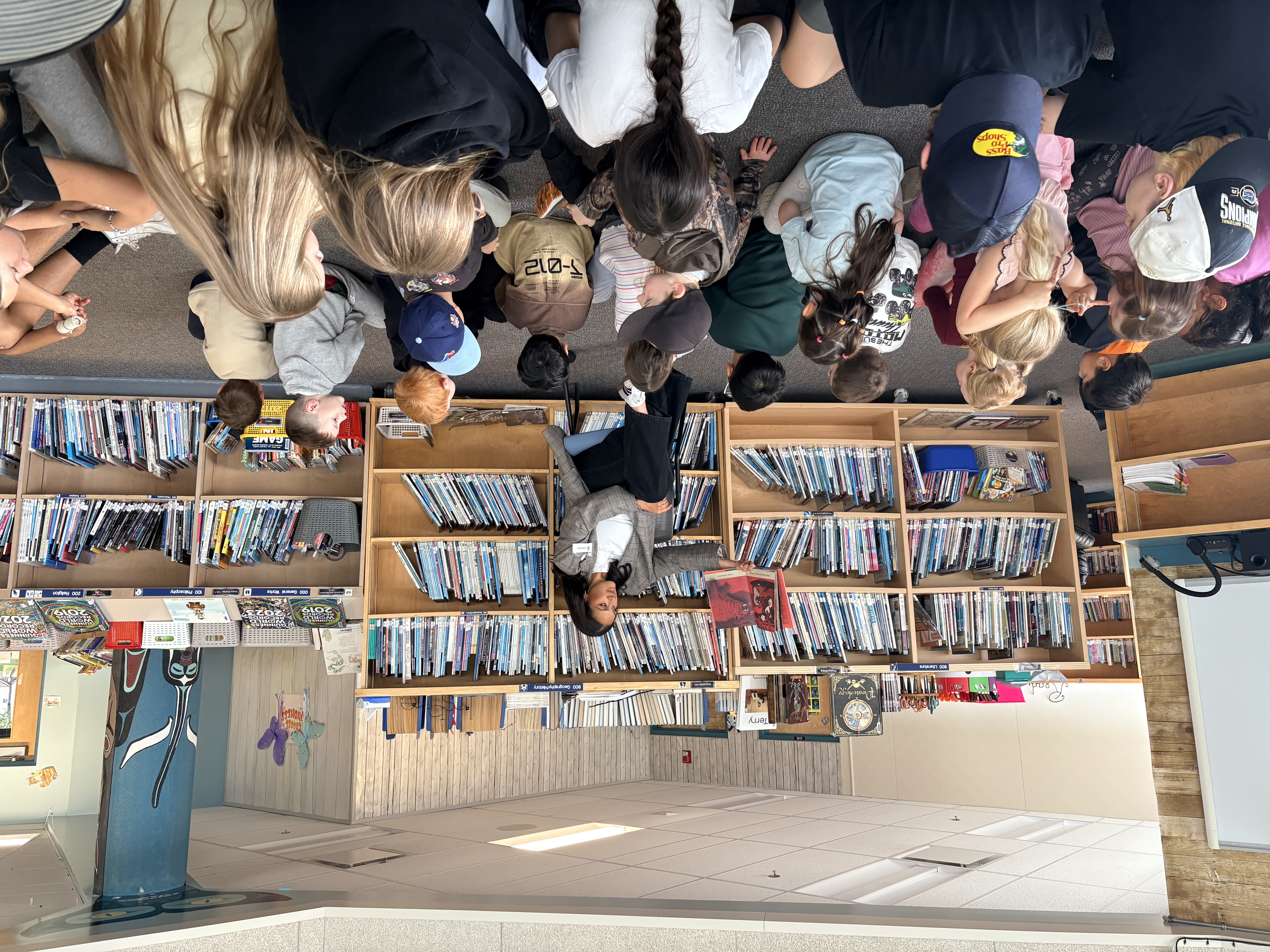 Dehara reading to students in school library